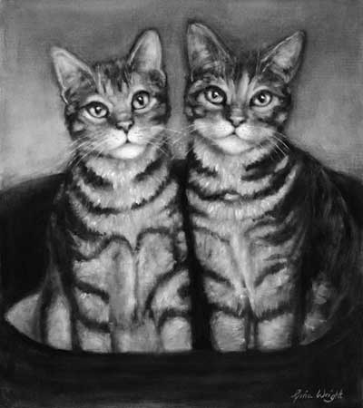 Two tabby cats sitting in their bed